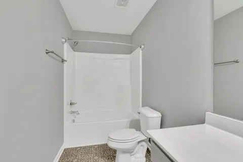a white toilet sitting next to a bath tub