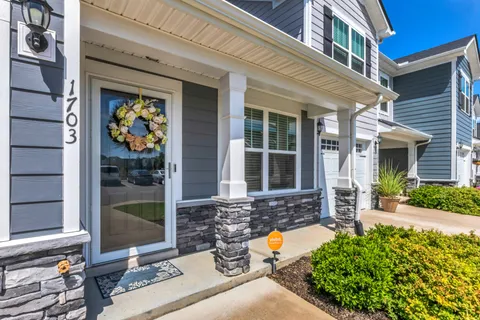 front view of a house with a large window and a yard