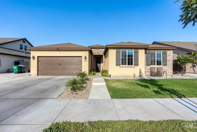 a front view of a house with a garden and plants