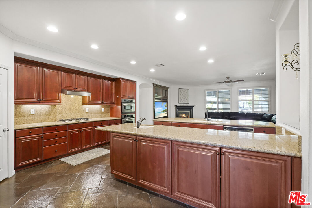 23871 Rio Ranch Way Valencia, CA 91354 - Photo 7 of 46 a large kitchen with stainless steel appliances wooden cabinets and a counter top space