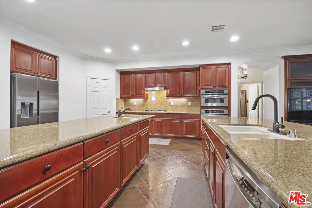 23871 Rio Ranch Way Valencia, CA 91354 - Photo 10 of 46 a kitchen with granite countertop a sink and cabinets