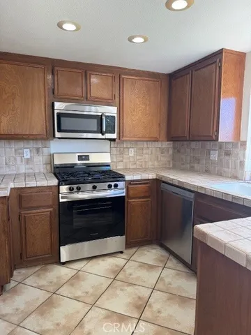 a kitchen with granite countertop a stove a sink and a microwave