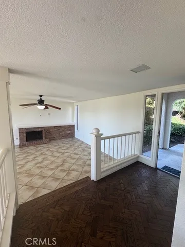 a view of a livingroom with wooden floor and a ceiling fan