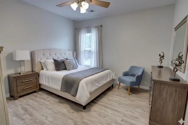 a bedroom with a bed and a lamp with wooden floor