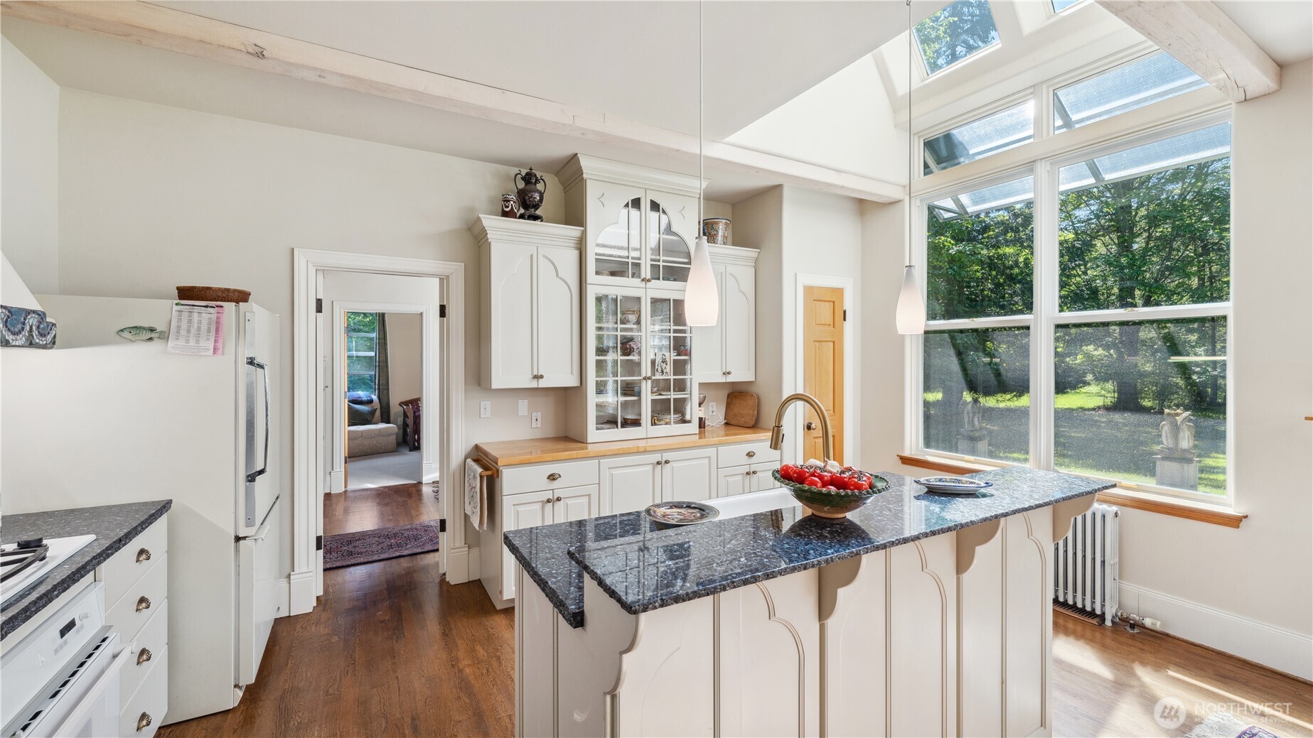 5513 Homestead Lane Anacortes, WA 98221 - Photo 12 of 37 a kitchen with granite countertop a stove a sink dishwasher and a dining table with wooden floor