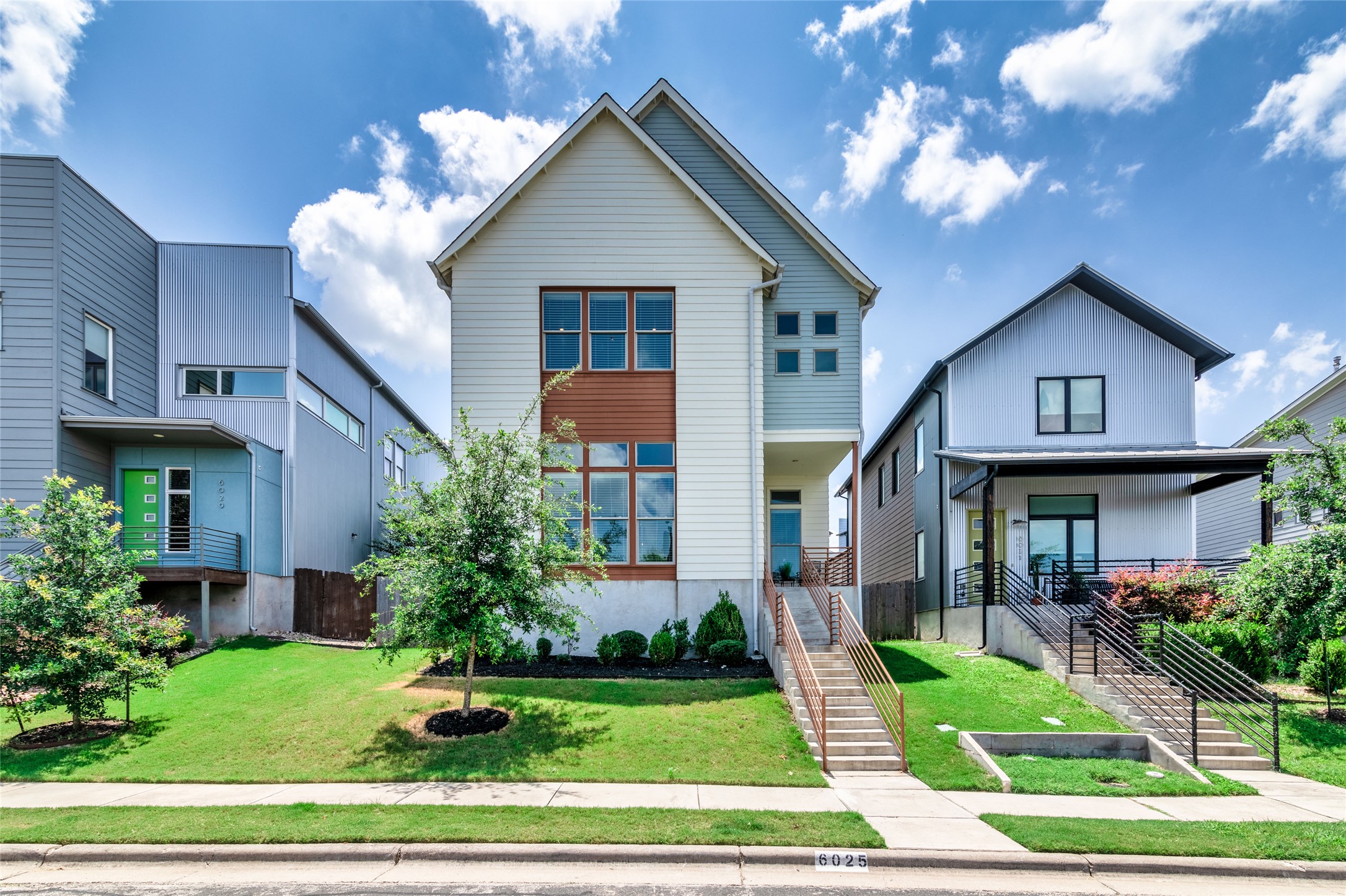 6025 Seville Drive Austin, TX 78724 - Photo 6 of 40 Contemporary style build, large window arrangements, manicured from lawn and a concrete staircase with metal handrails