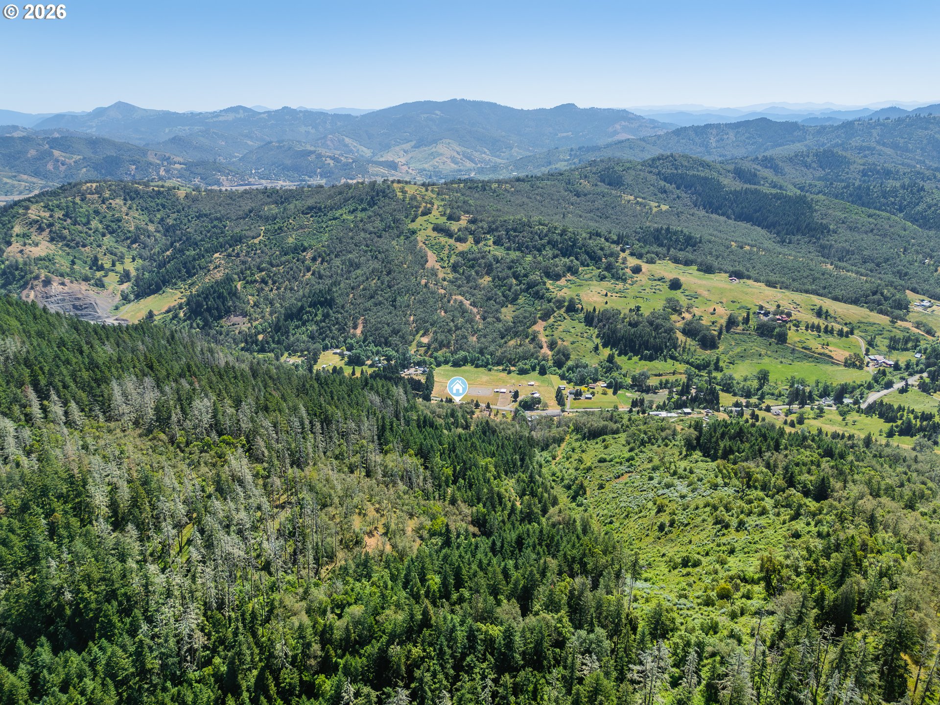 3707 Willis Creek Road Winston, OR 97496 - Photo 13 of 30 a view of a lush green hillside and a houses