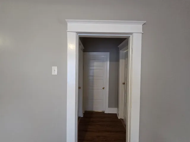 a view of a hallway with wooden floor