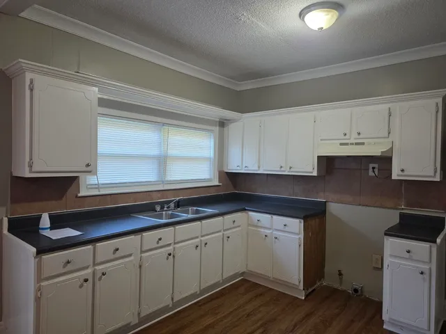 a kitchen with cabinets appliances a sink and a window