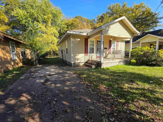 a front view of a house with yard and green space