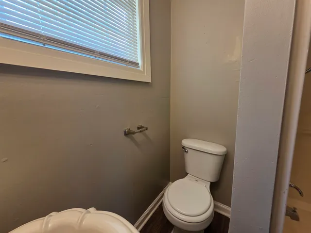 a white toilet sitting next to a white wall