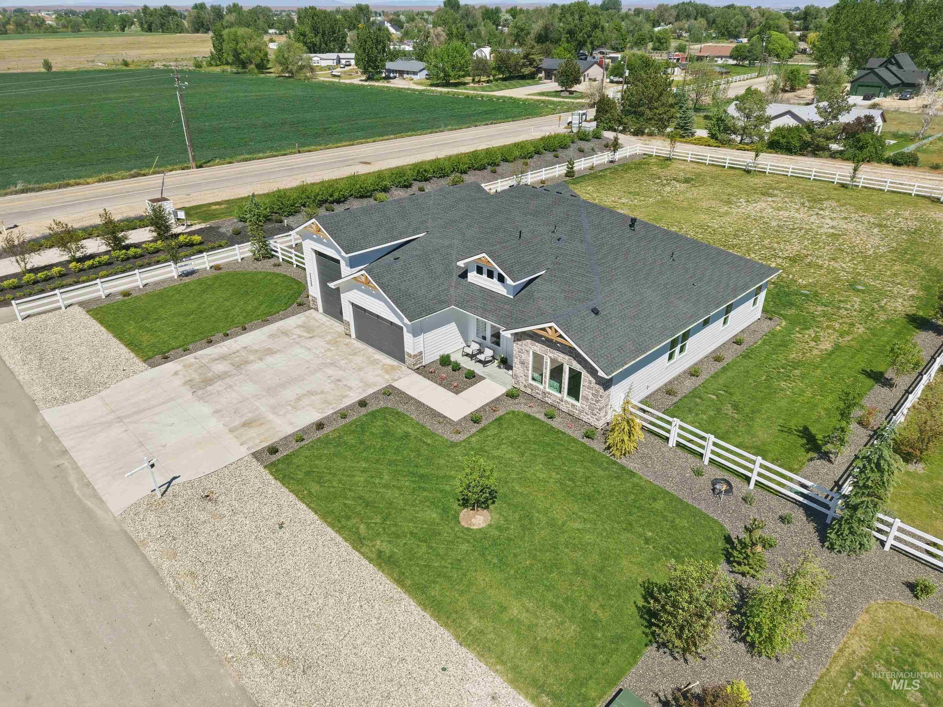 24990 Belgian Way Middleton, ID 83644 - Photo 45 of 50 Contemporary home featuring a dark gray shingle roof, light gray siding, and stone accents