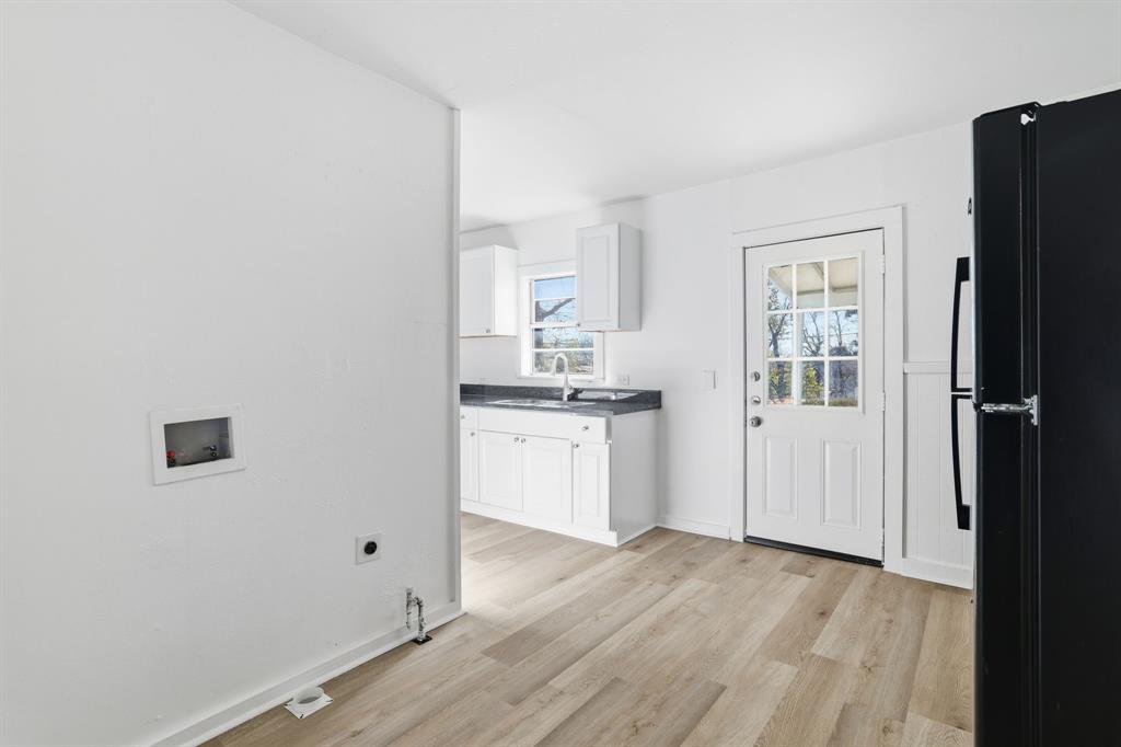 604 East Morton Street Denison, TX 75021 - Photo 7 of 22 a view of a kitchen with white cabinets and wooden floor