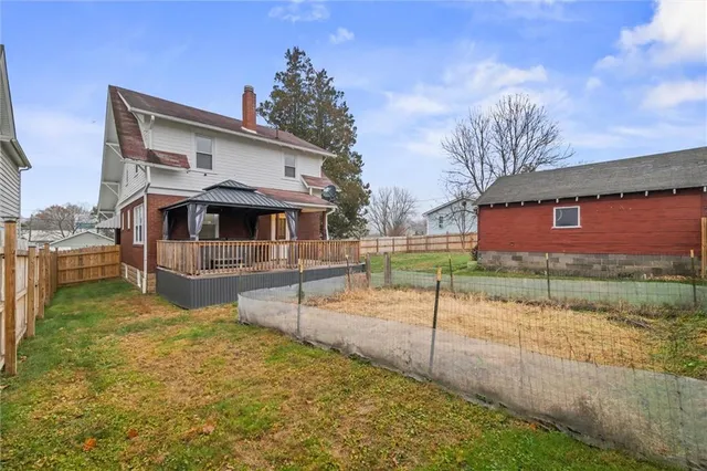 a view of a house with backyard and trees