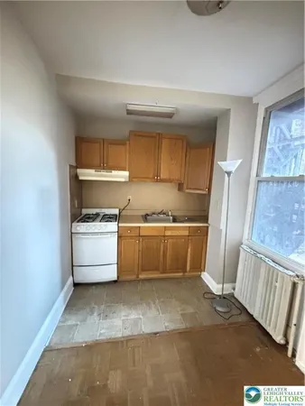 a kitchen with a stove a refrigerator and cabinets