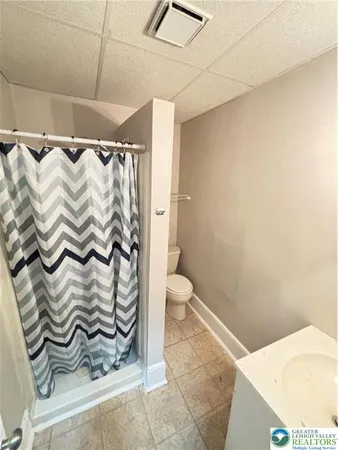 a bathroom with a toilet and a shower curtain