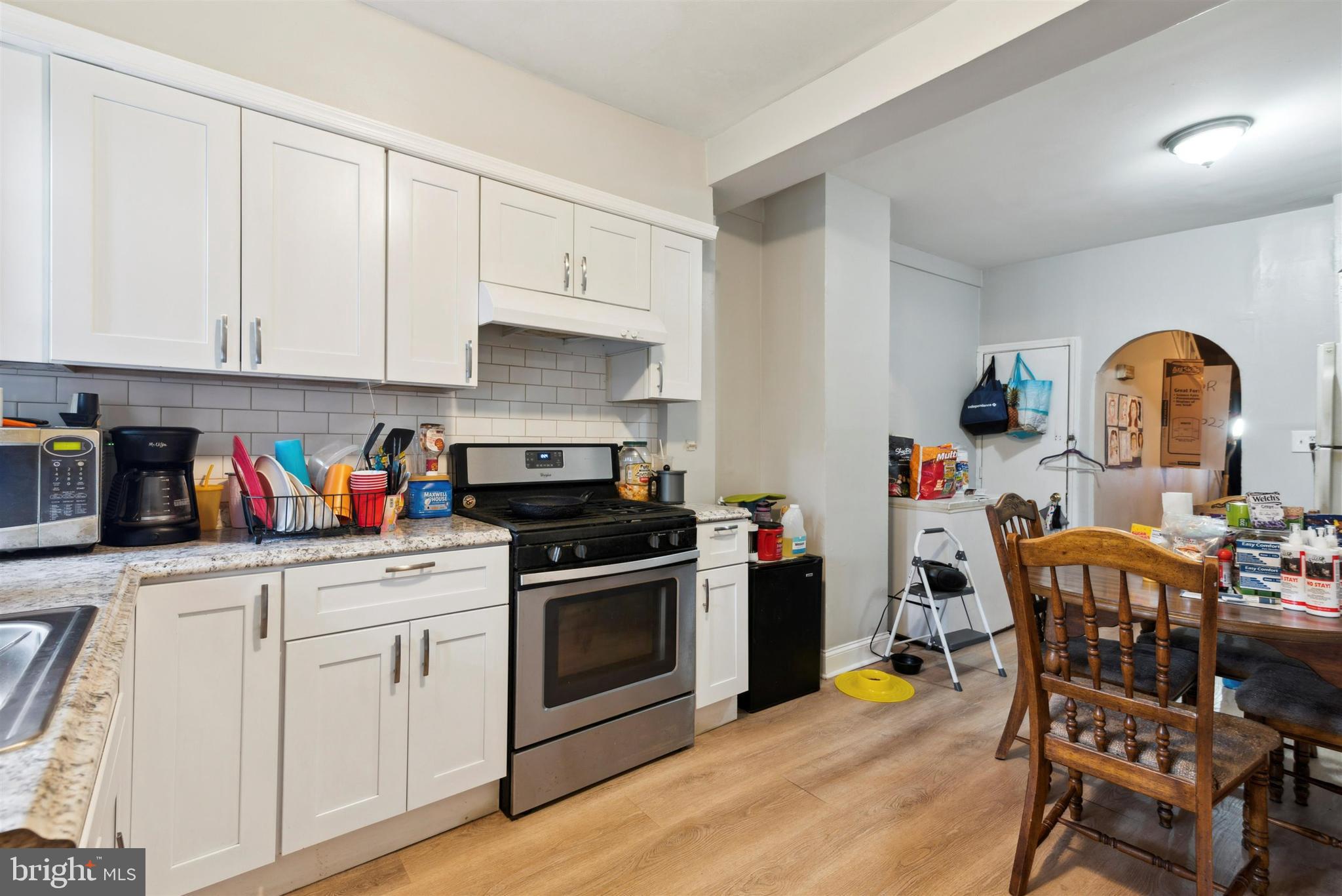 6124 Upland Street Philadelphia, PA 19142 - Photo 3 of 15 a kitchen with stainless steel appliances granite countertop a stove top oven a sink dishwasher and white cabinets with wooden floor