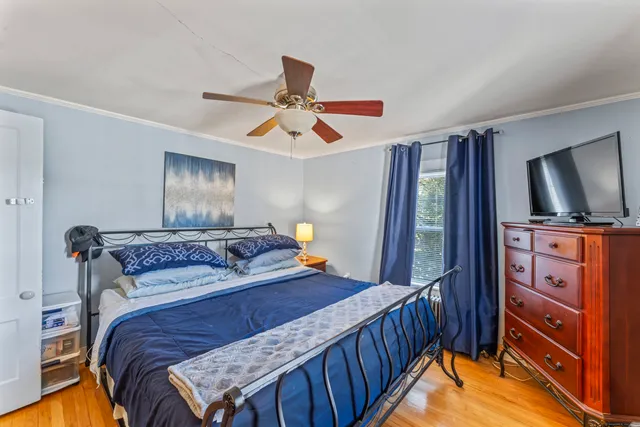 a bedroom with a bed and a flat tv screen on the dresser