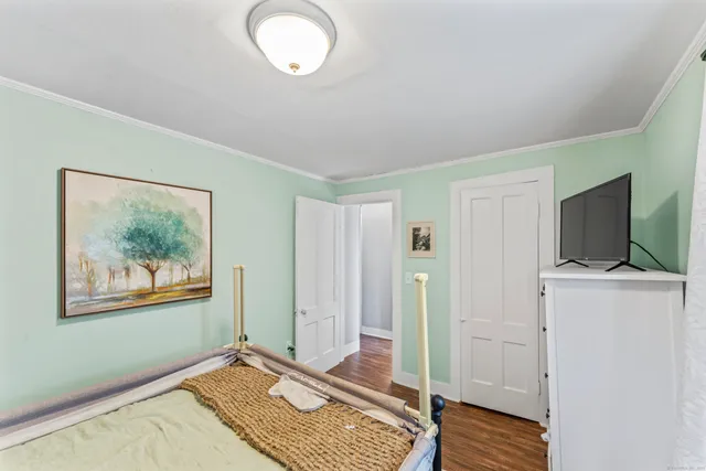 a view of a livingroom with wooden floor and a flat screen tv