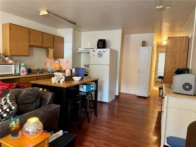 a kitchen with a sink appliances and wooden floor