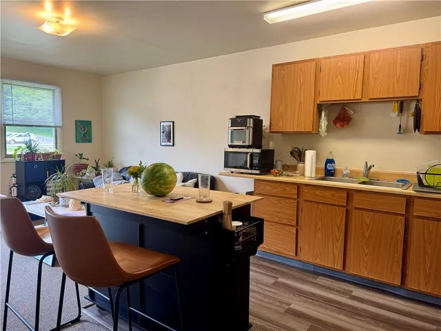 a kitchen with a sink a stove cabinets dining table and chairs
