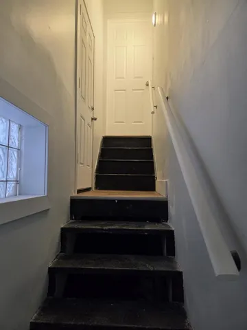a view of a small space with wooden floor and a window