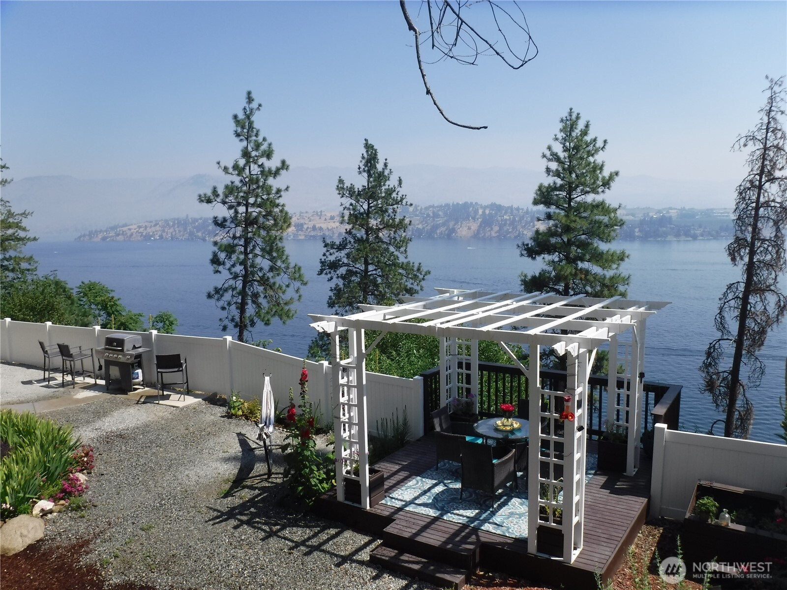 165 Granite Falls Road Chelan, WA 98816 - Photo 3 of 27 a view of a patio with table and chairs potted plants