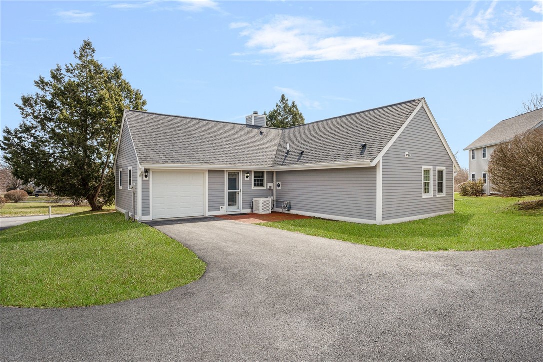 318 Corey Lane, Unit 318 Middletown, RI 02842 - Photo 31 of 31 Garage and Parking for two cares in tandem. Brick Patio and back door to the kitchen.