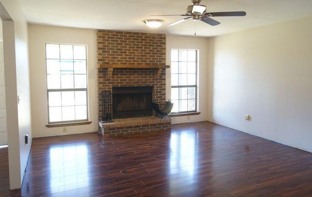 505 Ridge Lake Road Crestview, FL 32536 - Photo 2 of 18 an empty room with wooden floor fireplace and windows