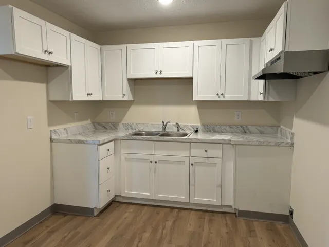 a kitchen with granite countertop white cabinets and white appliances
