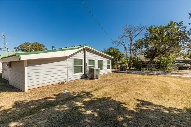 a front view of house with yard and trees in the background