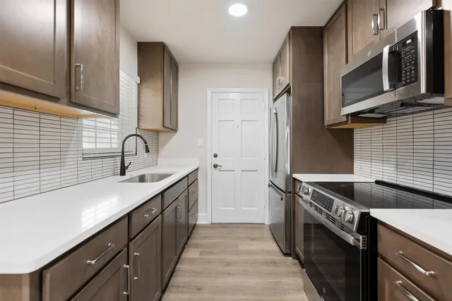 a kitchen with stainless steel appliances granite countertop a sink stove and refrigerator