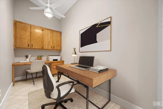 an empty room with kitchen and chandelier fan