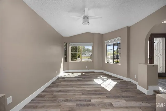 an empty room with windows and fireplace