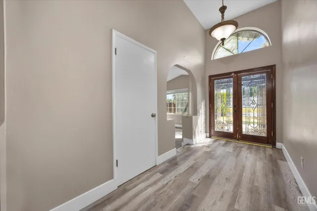 an empty room with windows and ceiling fan