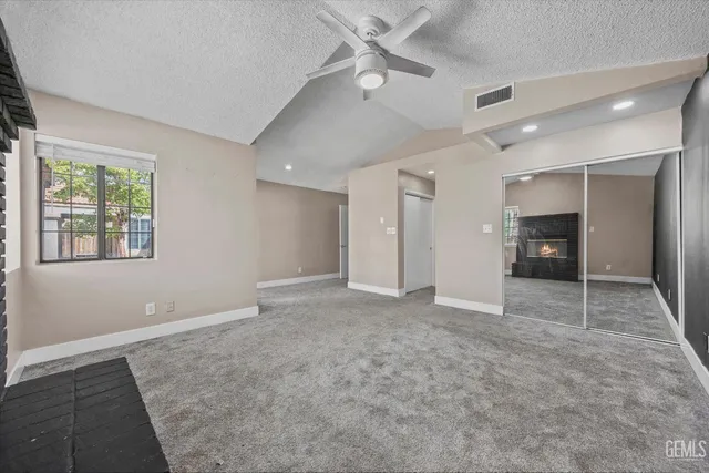 an empty room with a chandelier fan and closet