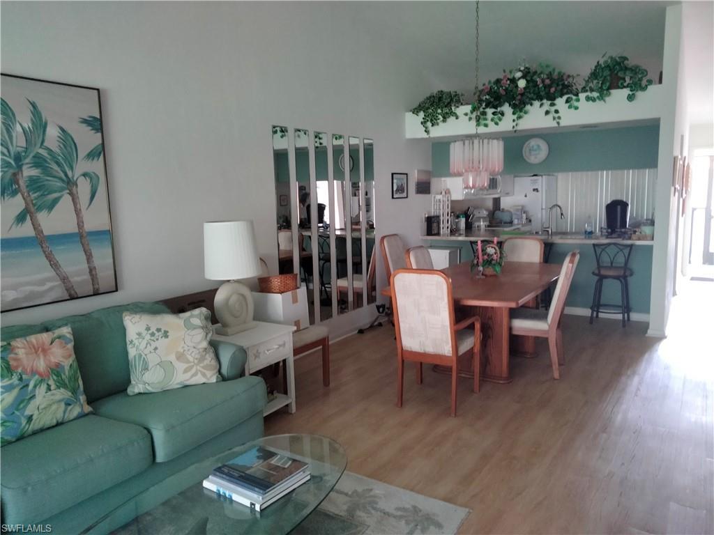 3535 Antarctic Circle, Unit 2302 Naples, FL 34112 - Photo 2 of 14 a view of a dining room with furniture and wooden floor