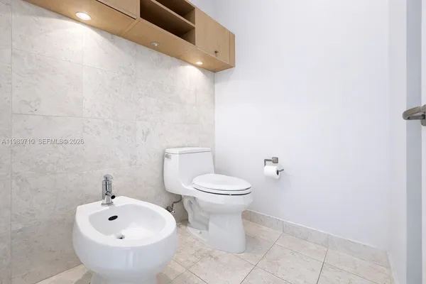 a white toilet sitting next to a white sink