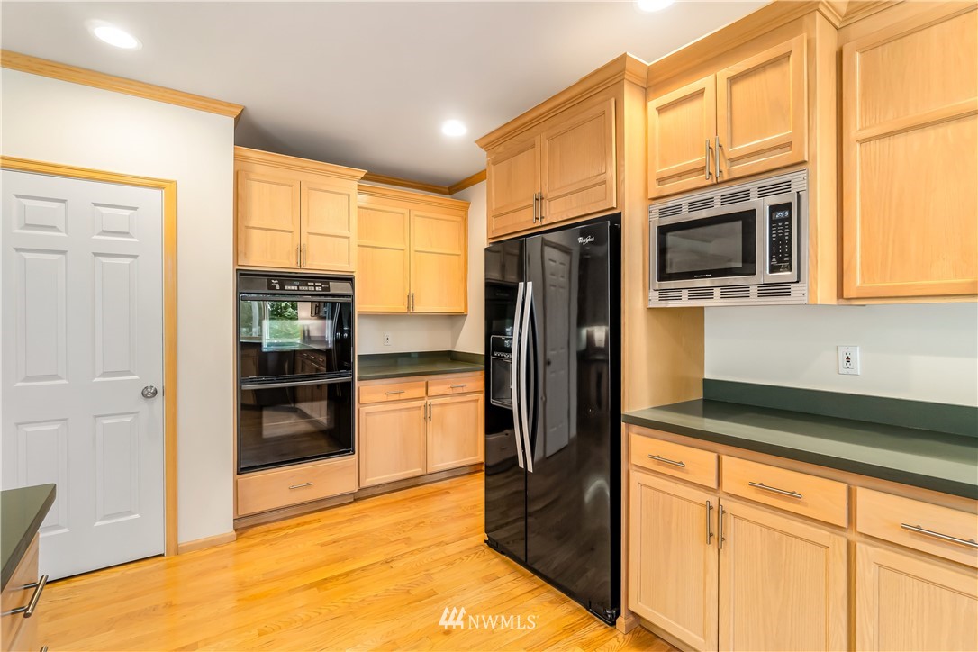 21518 30th Avenue Southeast Bothell, WA 98021 - Photo 14 of 40 a kitchen with stainless steel appliances granite countertop a refrigerator and a stove top oven