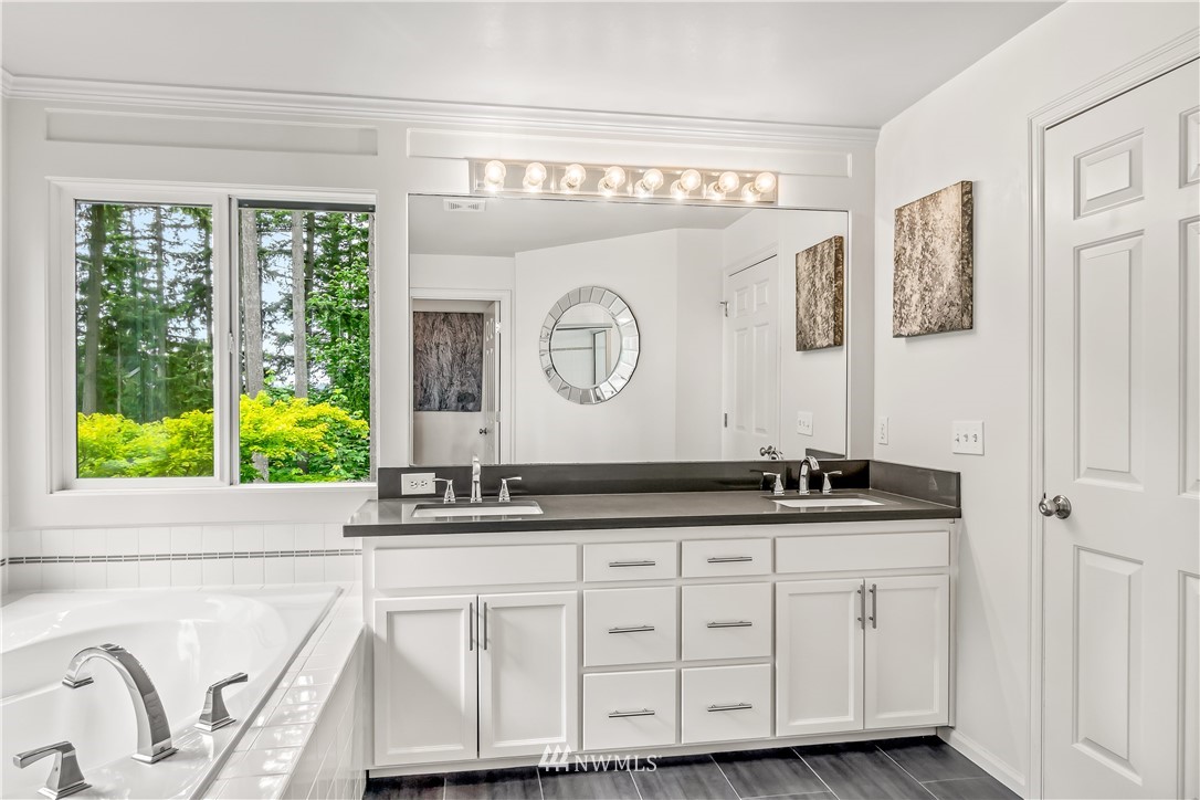21518 30th Avenue Southeast Bothell, WA 98021 - Photo 23 of 40 a bathroom with a granite countertop sink and a large mirror