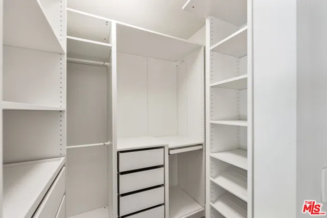 a view of walk in closet with empty racks