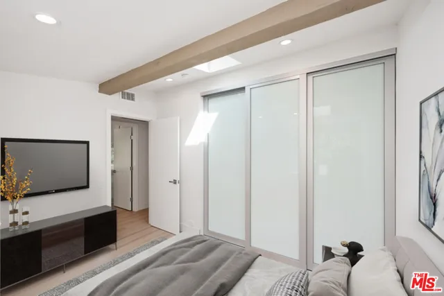 a living room with a flat screen tv furniture and a walk in closet