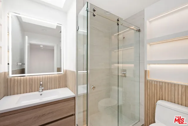 a bathroom with a tub shower sink and mirror
