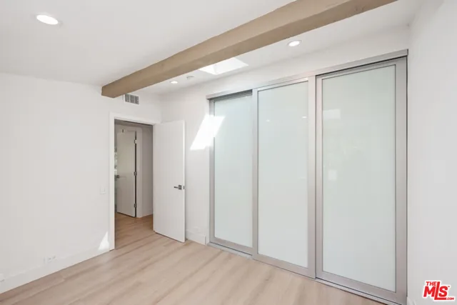 an empty room with wooden floor and closet