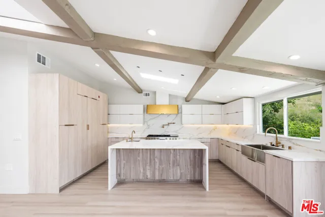 a living room with stainless steel appliances kitchen island granite countertop a sink cabinets and wooden floor