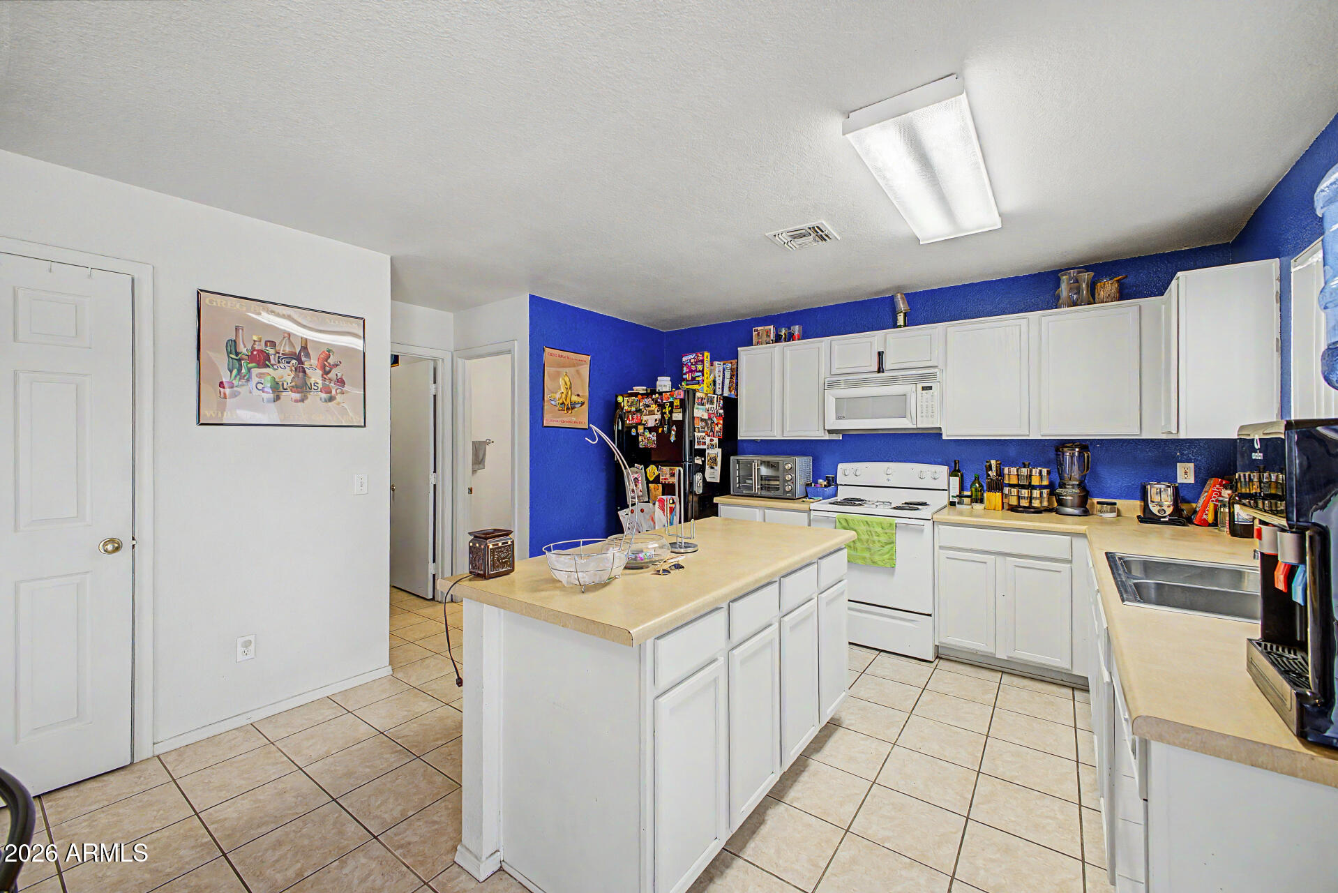 2607 West Bloch Road Phoenix, AZ 85041 - Photo 11 of 34 a kitchen with a sink a stove cabinets and counter space