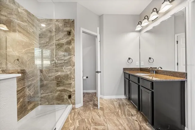 a bathroom with a granite countertop sink toilet and shower curtains