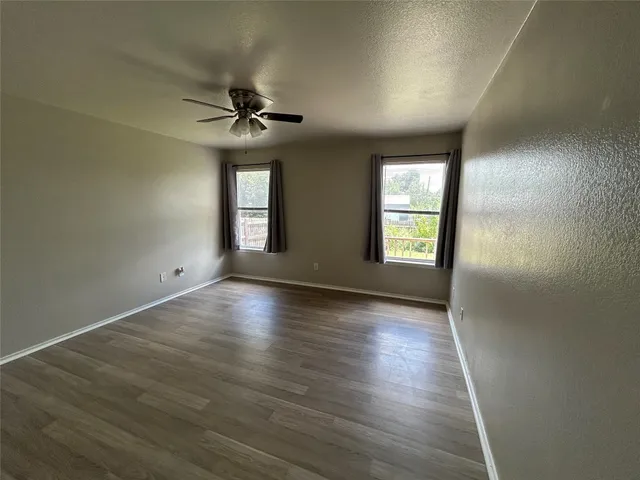 a view of a livingroom with furniture wooden floor and a ceiling fan
