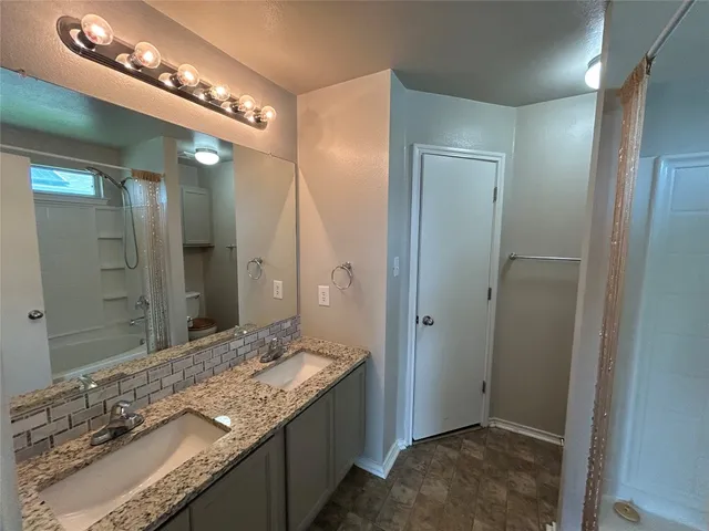 an empty room with wooden floor chandelier and windows