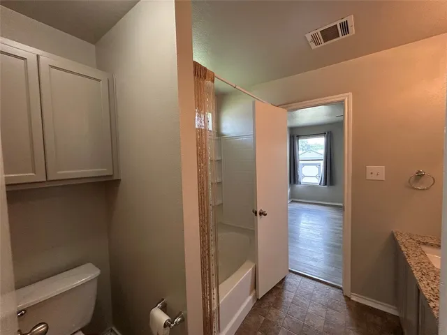 a bathroom with a granite countertop sink a large mirror and a shower